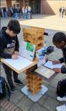 2 Jungen an Outdoor Lernsäule arbeitend, mit Tabletts, 3.3.2026